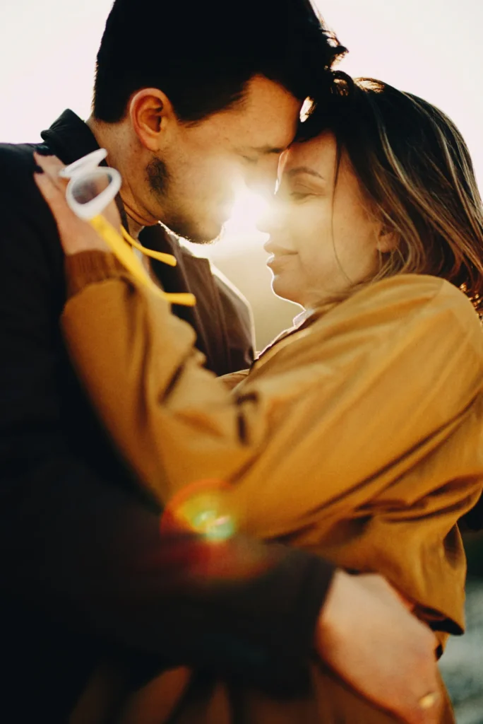 Couple embracing in warm golden hour light during an intimate portrait session